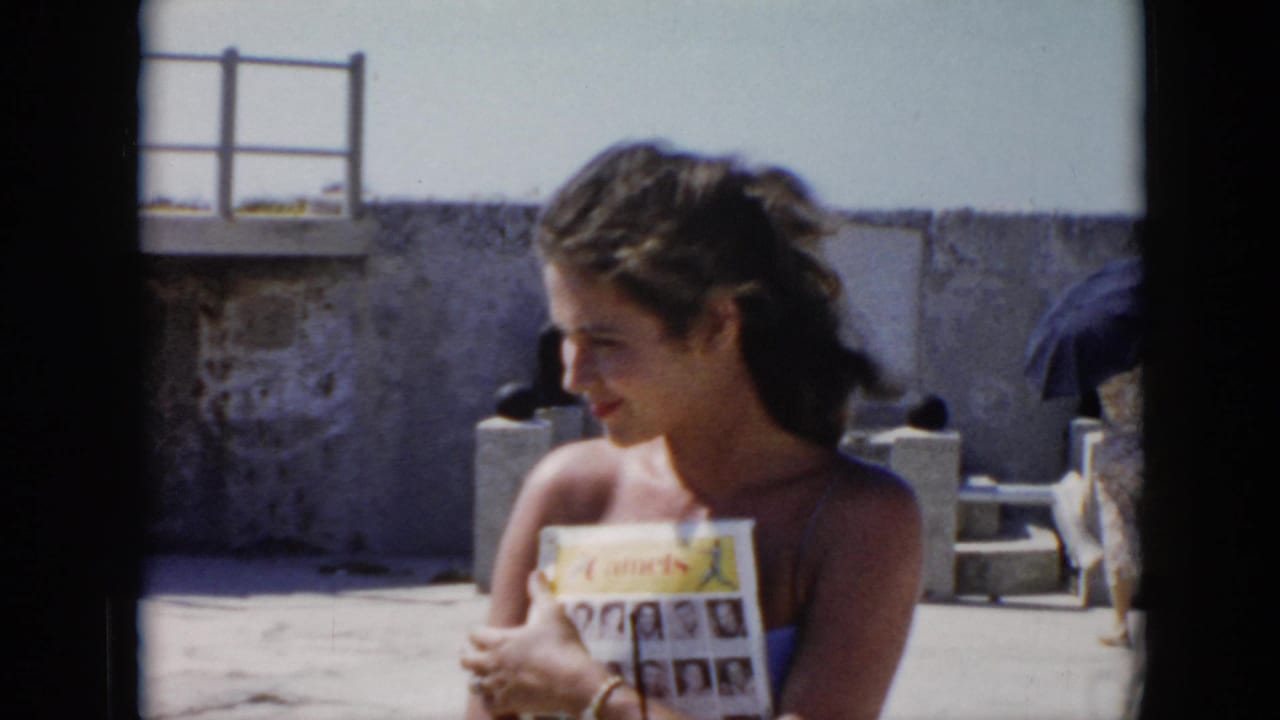 Young woman holding a magazine and looking to the side in bright sunlight.