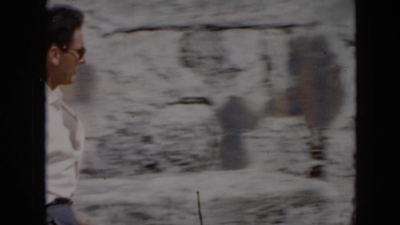 1956 Cuba home-movie frame showing a man in a white shirt near weathered stone walls, partly blurred by handheld movement.