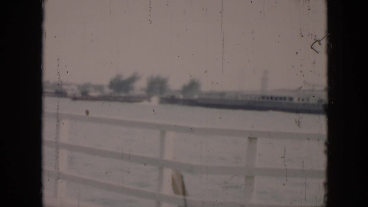 Distant shoreline and railing seen through dark film-frame edges.