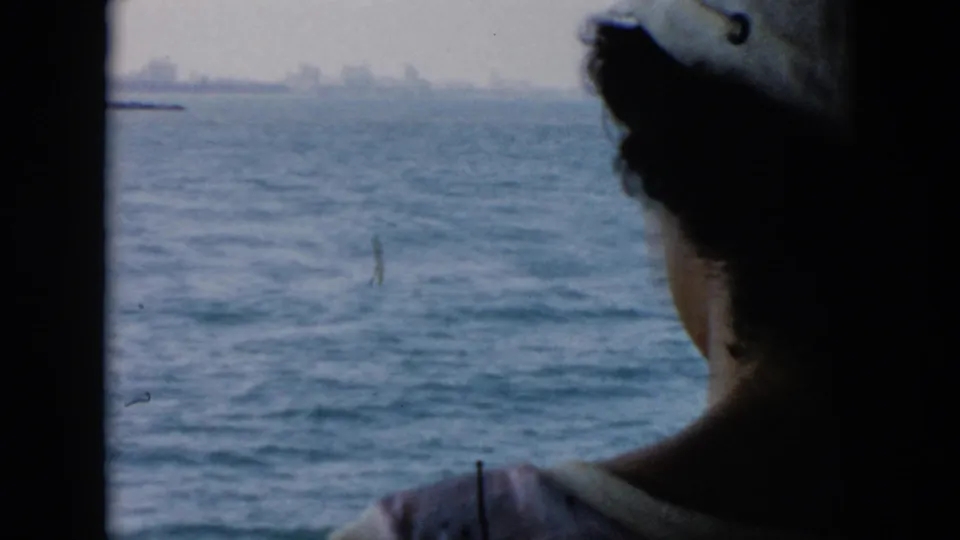 1956 Cuba-associated 8mm frame shifting from the wheelhouse toward open water, with a silhouetted person in the foreground.