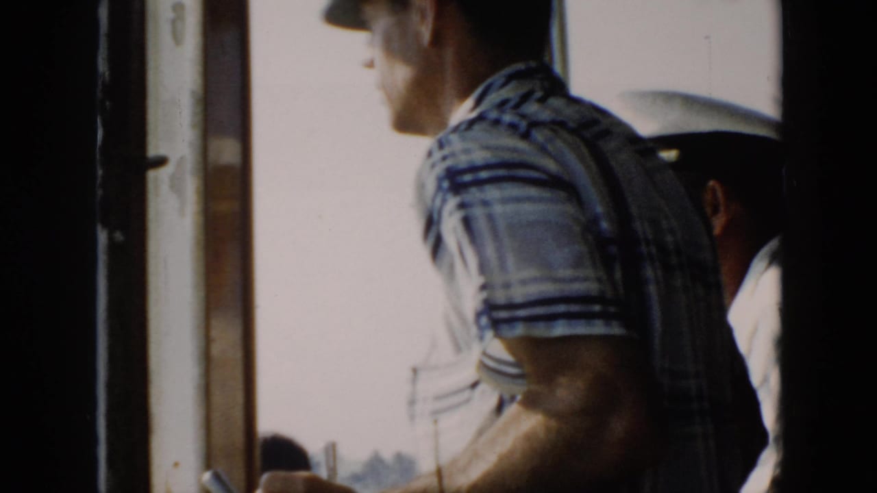 Plaid-shirted boat occupant beside a white-capped person, framed tightly by the side of the boat.