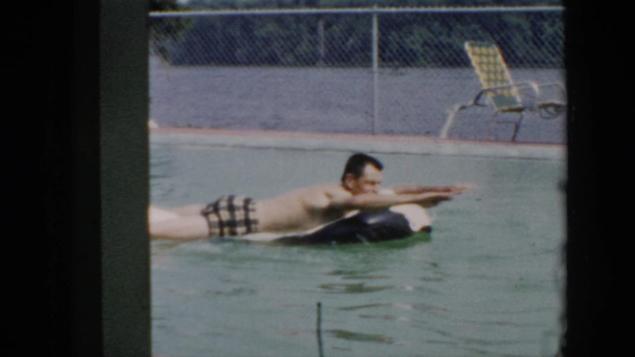 In 1956 Cuba home-movie footage, a man in plaid swim trunks floats on a black inner tube in a swimming pool.