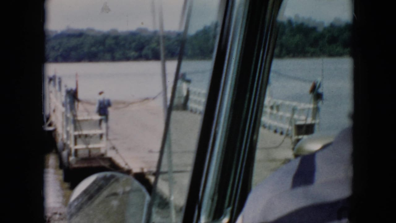 1956 Cuba home-movie view from inside a boat or cabin as a wooden dock and calm river appear ahead through window frames.