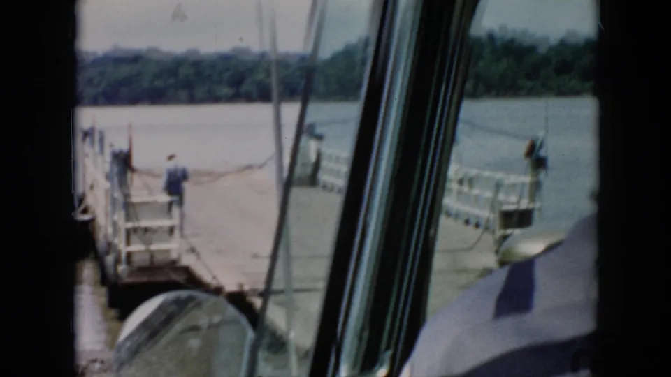 1956 Cuba home-movie view from inside a boat or cabin as a wooden dock and calm river appear ahead through window frames.