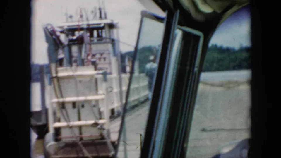 The boat sits close to a wooden dock in 1956 Cuba footage, with railings, cabin glass, water, and people near the landing visible.