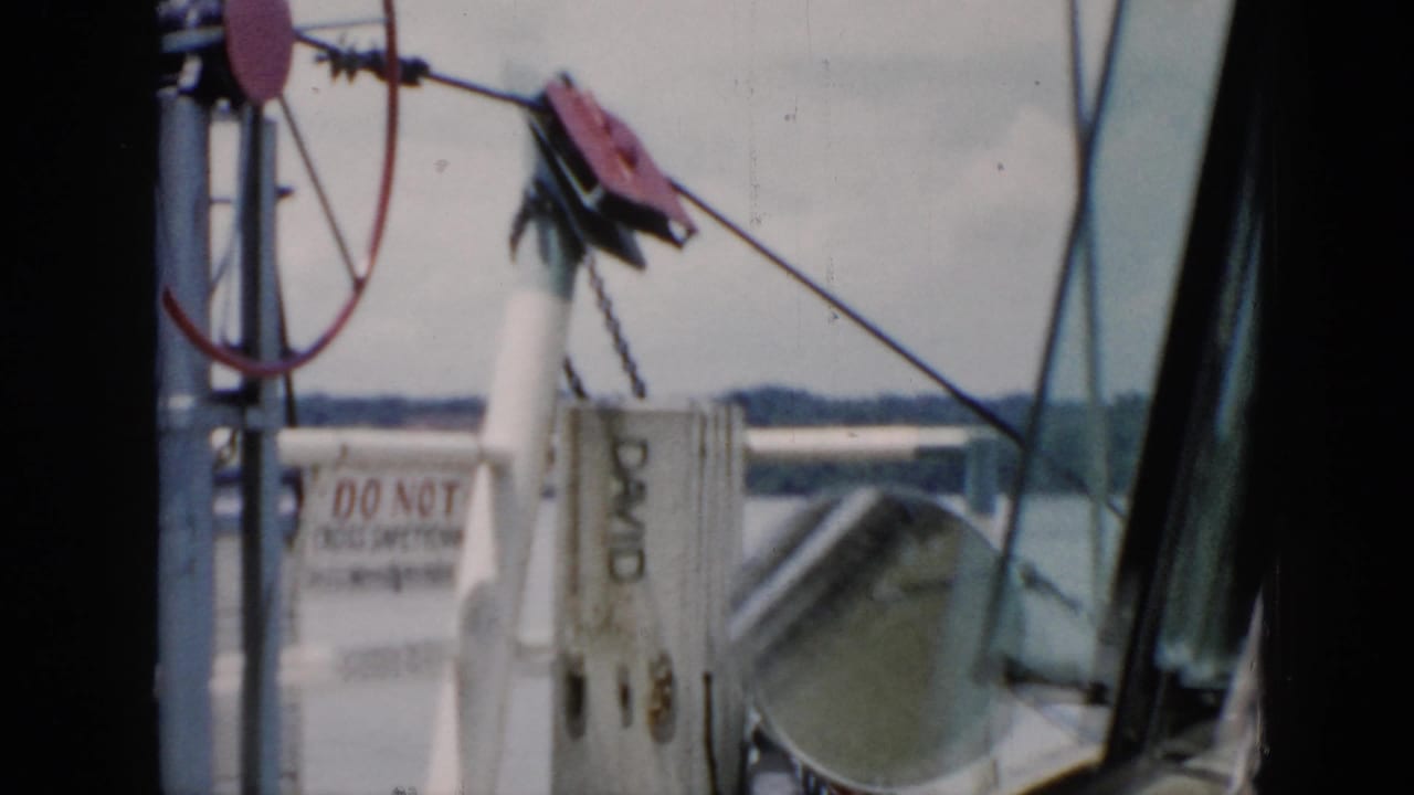 Ferry deck equipment and railings seen through a car windshield.