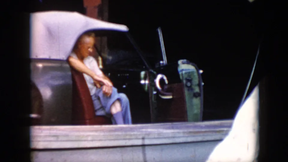 The 1956 Cuba footage shows a man seated in an open car, with heavy shadowing and visible 8mm frame edges.