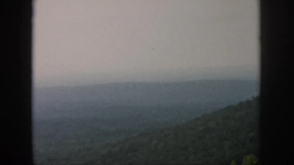 The 8mm frame shows a fog-dimmed valley and green forest slope, with the supplied Dayton, Ohio 1958 context.