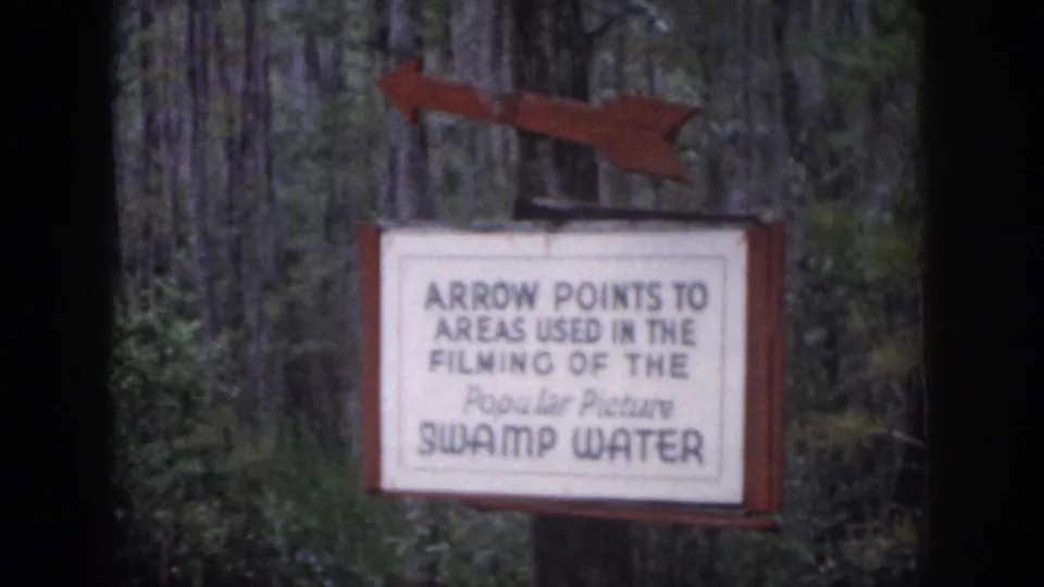 1958 Dayton, Ohio 8mm frame with a readable sign pointing toward areas used in the filming of Swamp Water.