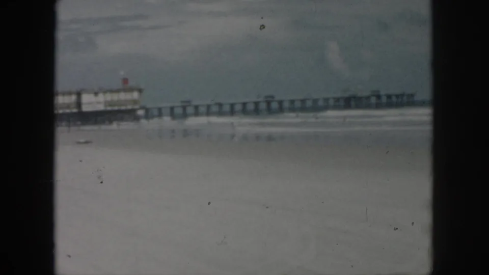 1958 New Orleans beach view with the truck leaving frame and the long pier and surf line dominating the scene.