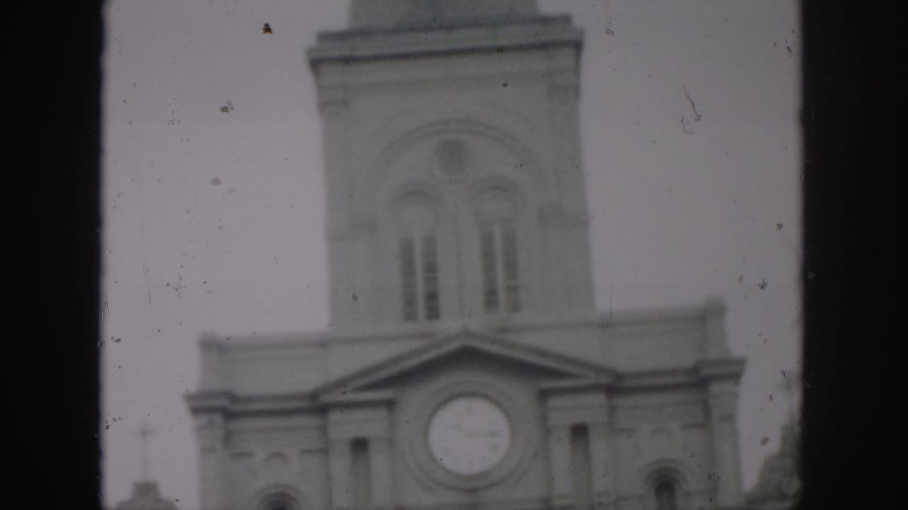 1958 New Orleans frame of a church clock tower and arched upper windows, with heavy film borders and soft exposure.
