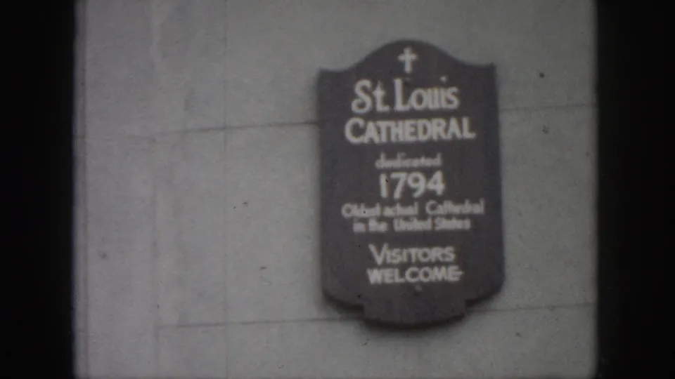 Soft 8mm frame of the St. Louis Cathedral sign in New Orleans, with 1794 text and visible film grain.