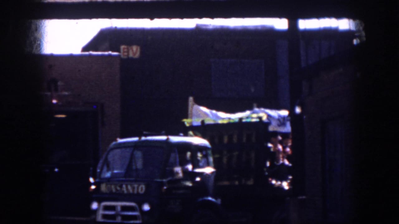 1958 Virginia parade footage shows a dark Monsanto truck leading or beside a decorated float with people and a white banner.