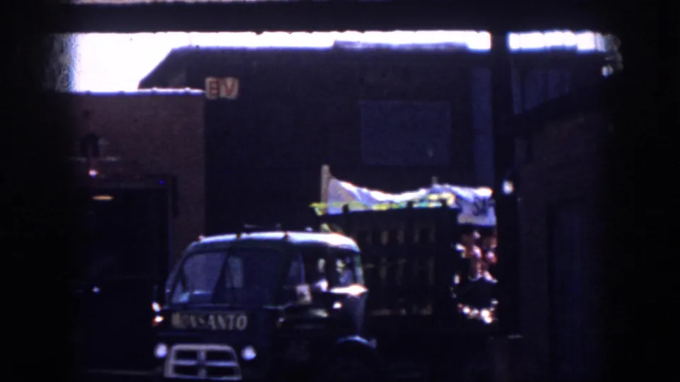 1958 Virginia parade footage shows a dark Monsanto truck leading or beside a decorated float with people and a white banner.