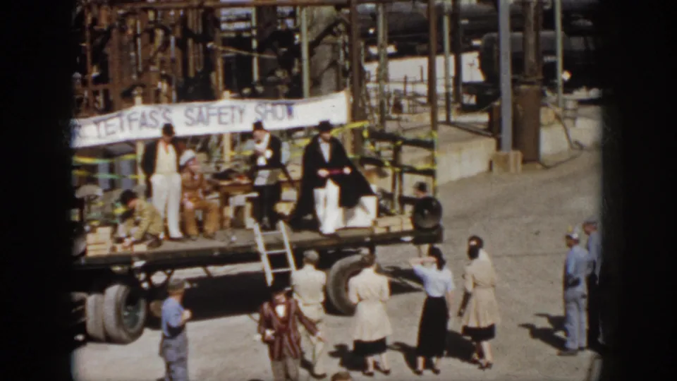 1958 Virginia frame with suited performers on a flatbed truck stage, spectators nearby, and a Dr. Tefas safety banner across the back.