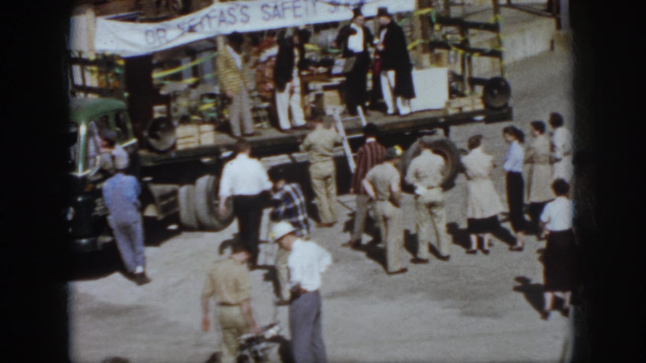 1958 Virginia scene with spectators watching a safety-show truck stage and a presenter in a white hat.