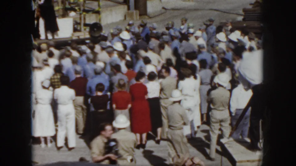 Virginia 1958 home-movie frame showing workers and attendees gathered outdoors at an industrial safety presentation.