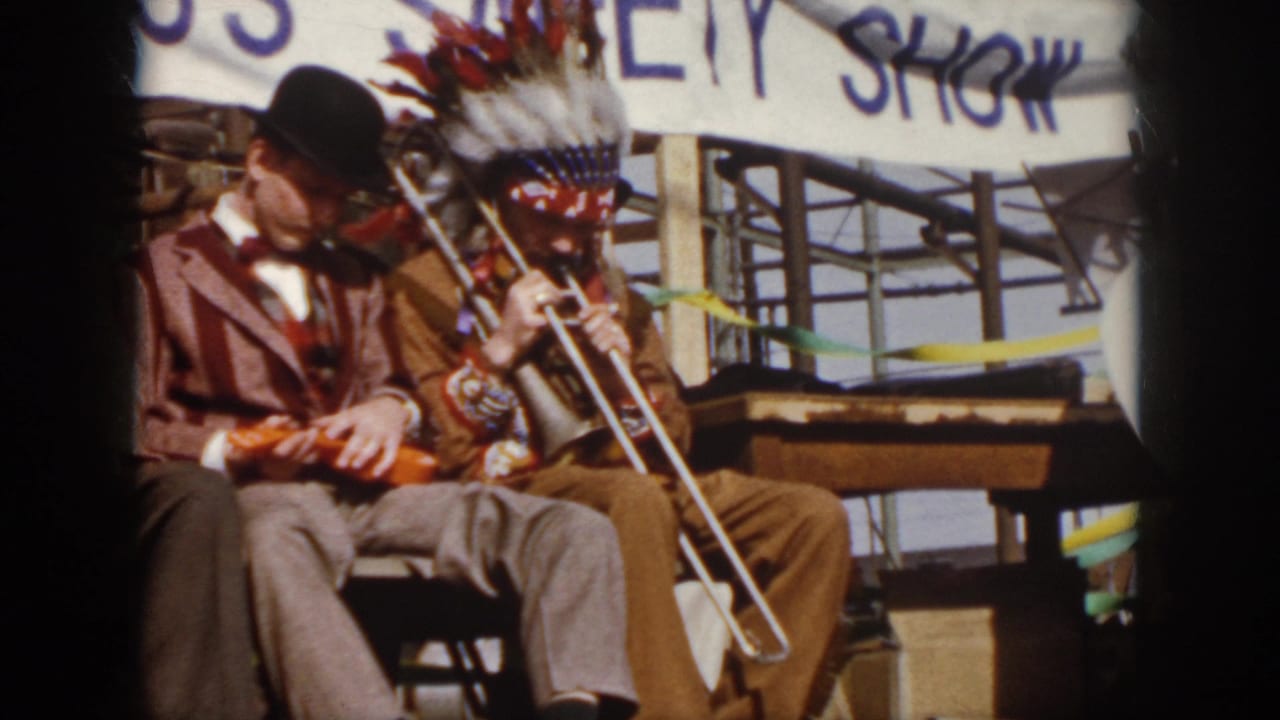 Seated musicians perform beneath a hand-painted safety show banner.