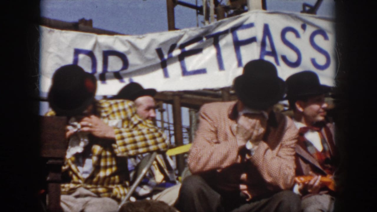 1958 Virginia frame showing performers seated under a banner reading partly DR. YETFAS'S, with hats, plaid costume, and trombone visible.