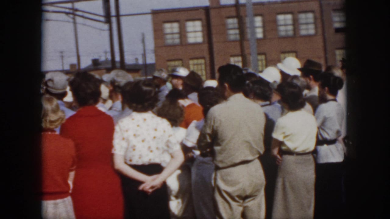 1958 Virginia crowd shot showing adults gathered outdoors in front of a brick building during a public event.