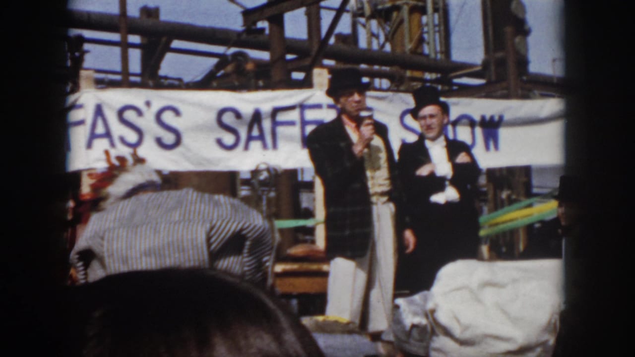 1958 Virginia home-movie view of a staged safety presentation with formal-dressed men and audience heads in front.