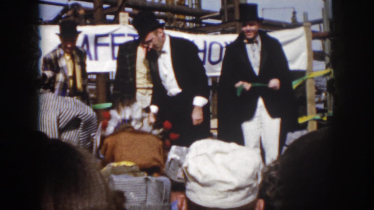 Costumed men perform before a crowd beneath a SAFETY SHOW banner.