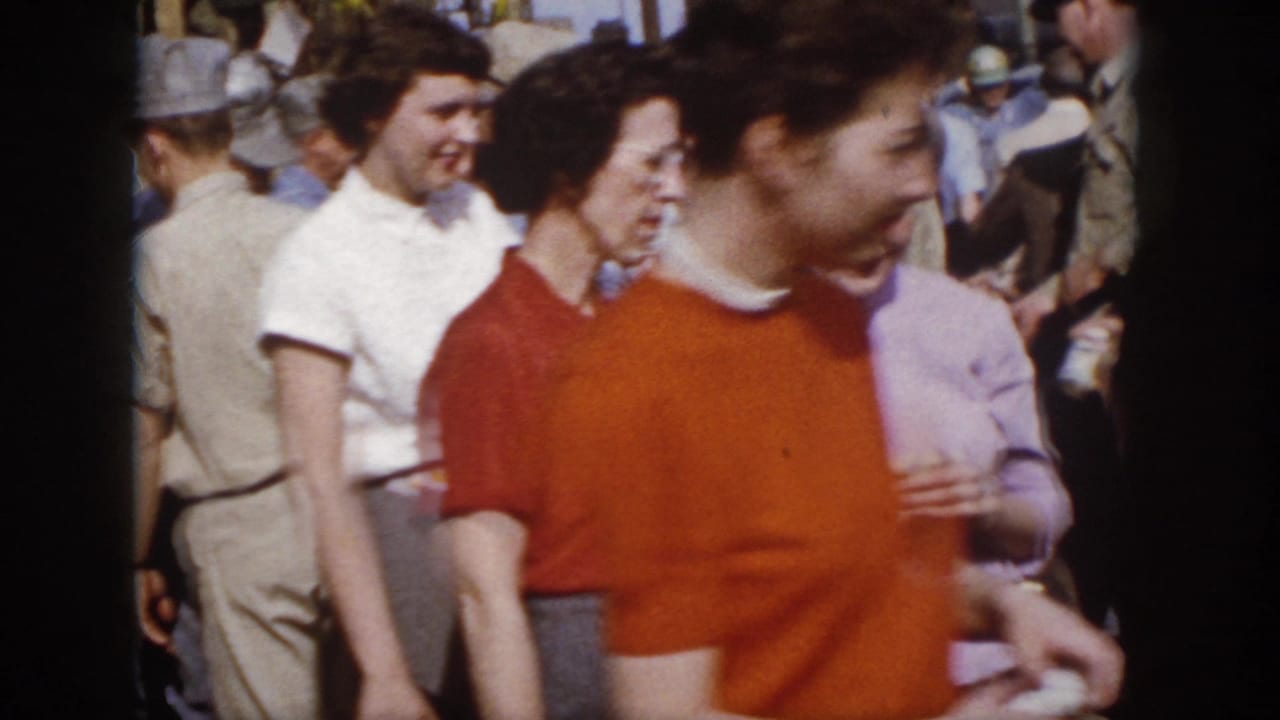 1958 Virginia crowd footage shows women in red, white, and lavender tops walking among adults at an outdoor public event.