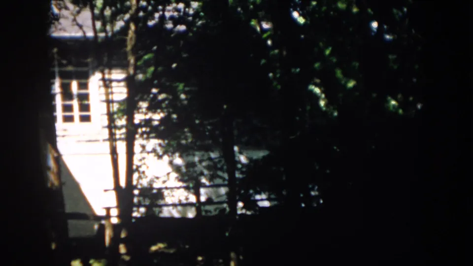 A final 1958 Virginia frame shows the house exterior still obscured by trees, with strong contrast between shade and sunlit siding.