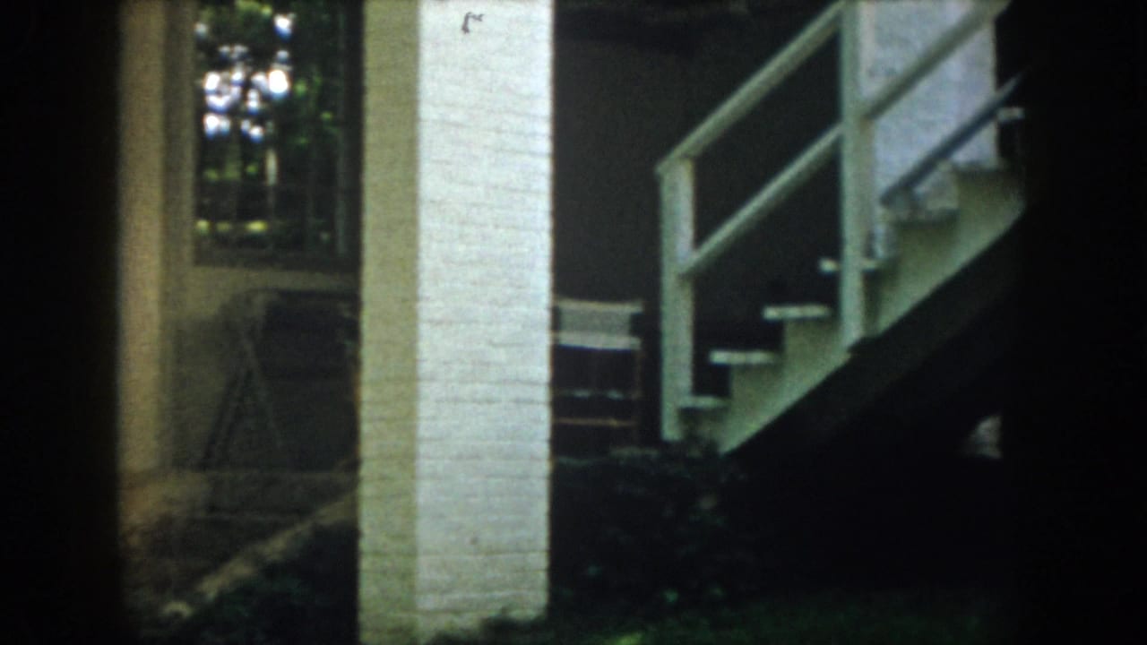 White brick pillar, exterior stairs, railings, and shaded lodging details appear in this 1958 Virginia 8mm frame.