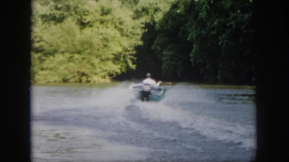 The small motorboat recedes down the tree-lined Virginia river, its wake spreading across the soft, grainy 8mm frame.