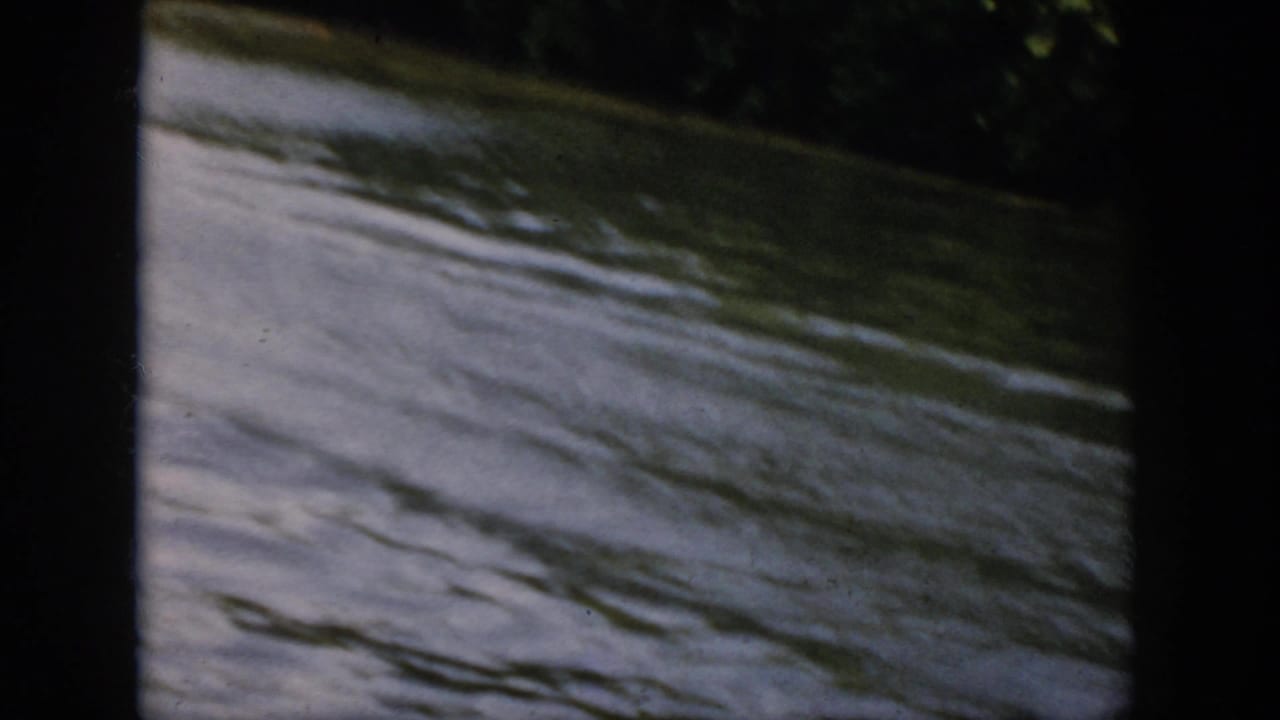 1958 Virginia river surface with soft ripples and a dark vertical scan edge, likely following the passing motorboat.