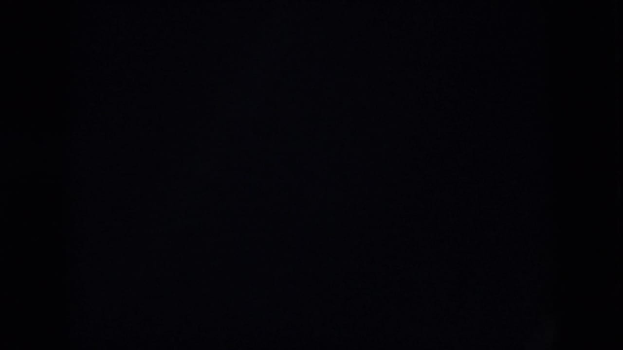 Dark 1958 Virginia home-movie frame with indistinct interior shapes and little visible detail.