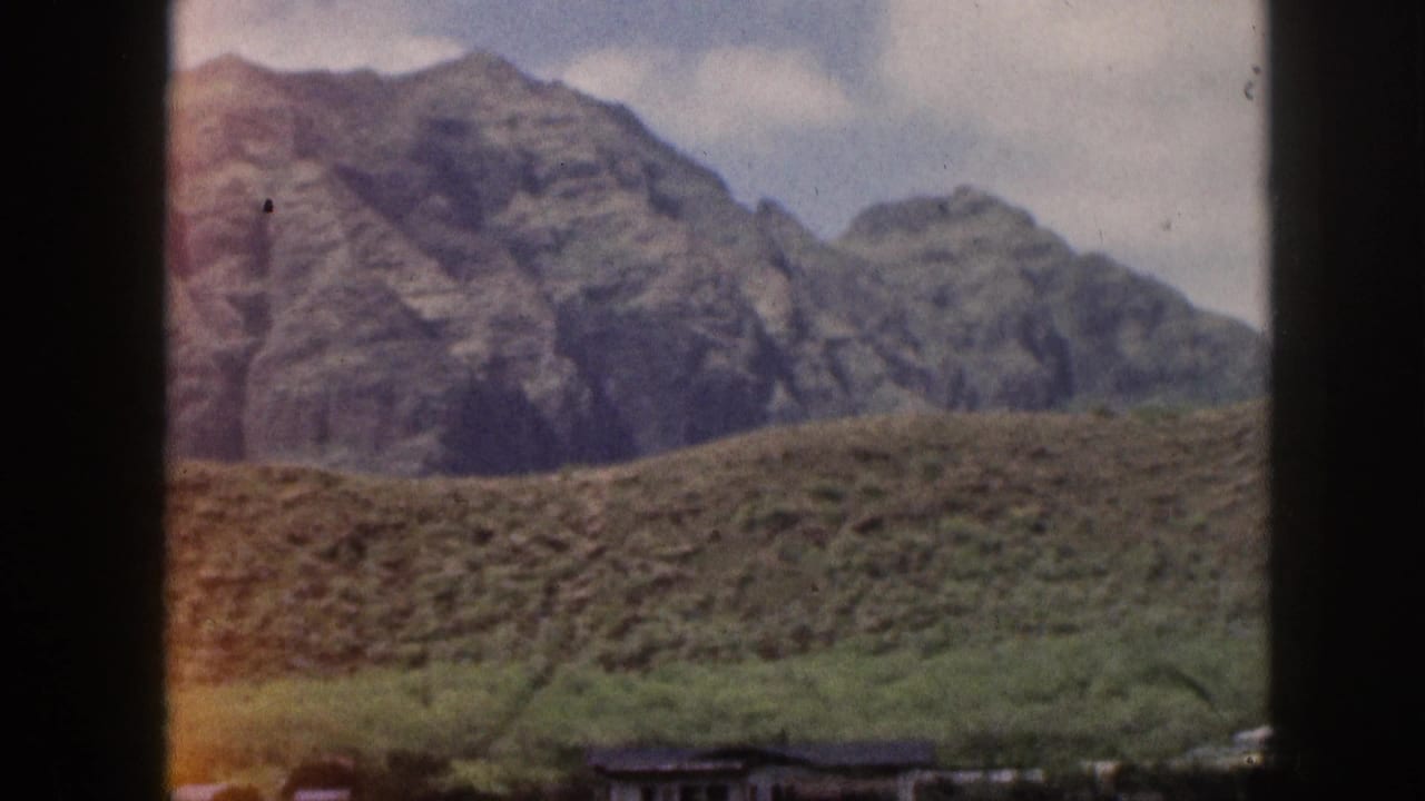 Mountain ridge and green slope with dark framing at the sides and center.