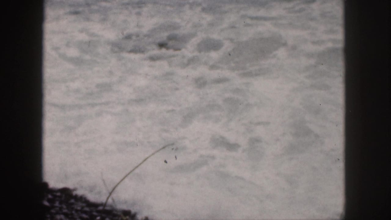 Choppy surf fills the frame with a dark center divider.