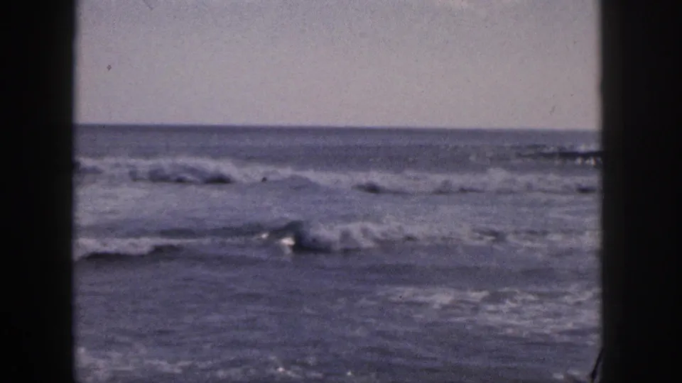 1959 Hawaii home-movie frame showing mild ocean waves and a steady horizon through an 8mm gate border.