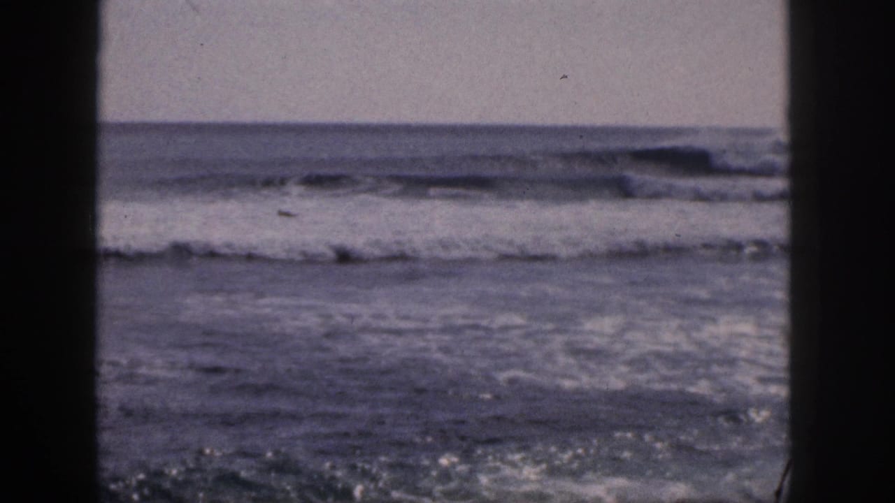 Choppy ocean waves seen through dark vertical framing.