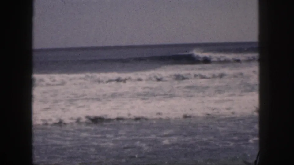 1959 Hawaii coastal view with white surf breaking across gray-blue water behind a dark central frame edge.