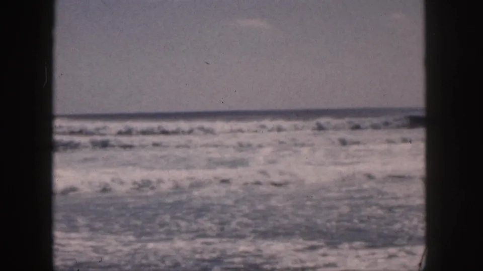 1959 Hawaii 8mm frame of choppy surf and white water, framed by dark edges with no people clearly visible.