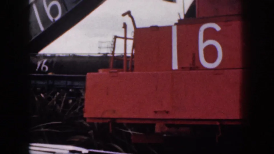 1959 Hawaii frame showing a red industrial or agricultural machine marked 16, cropped tightly by the home-movie camera.