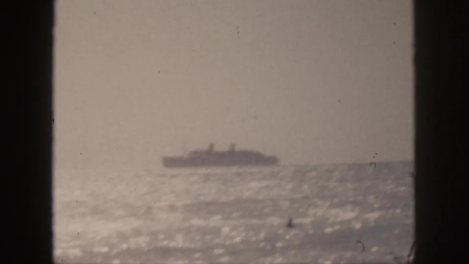 Soft 8mm view from Hawaii in 1959 of a distant ocean liner against bright water and a muted sky.
