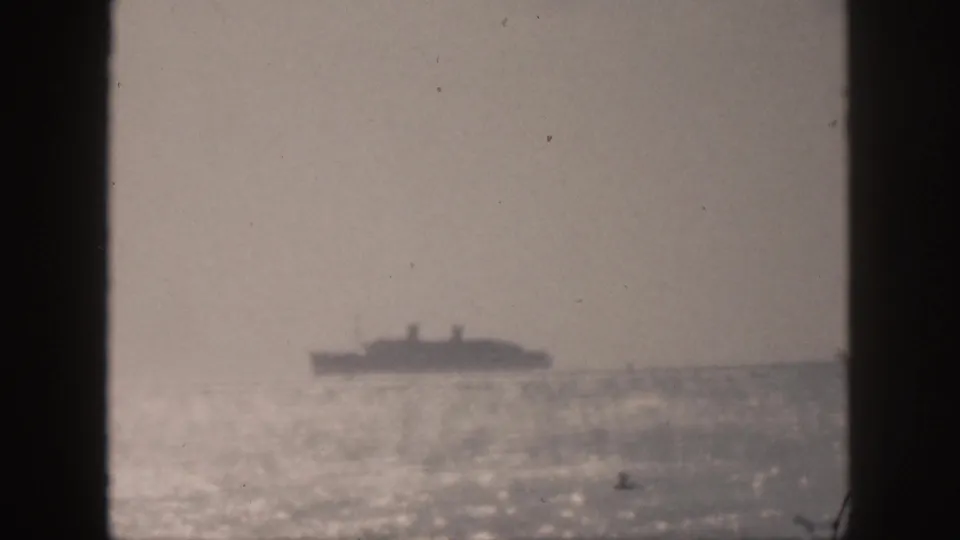 1959 Hawaii 8mm frame showing a distant liner near the horizon, with dark side borders and visible film grain.