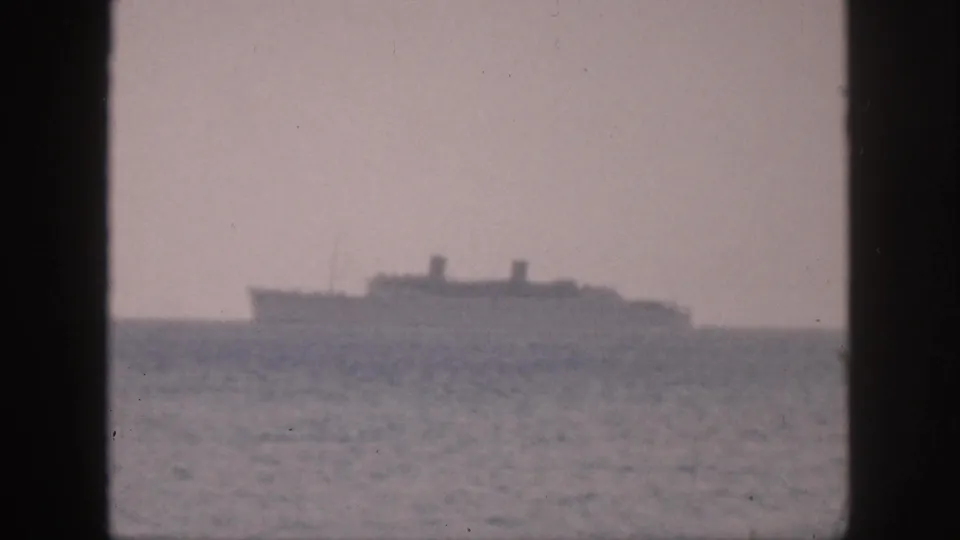 Distant large vessel off Hawaii in 1959, softly rendered by grain and haze in 8mm footage.