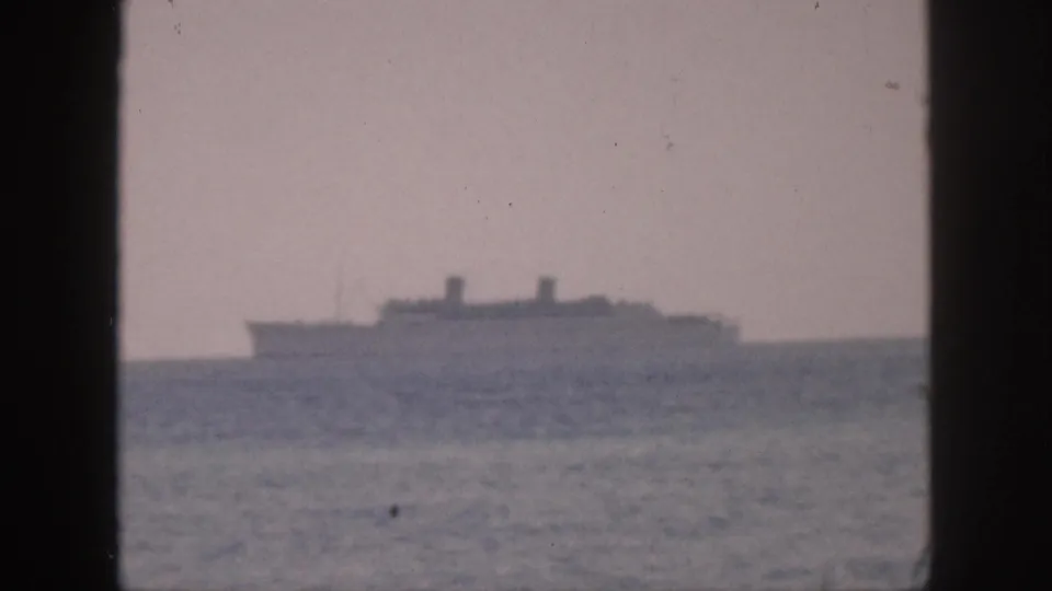 Distant cruise ship or passenger vessel off Hawaii in 1959, framed by a dark central edge and soft 8mm grain.