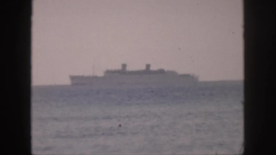 Soft 8mm home-movie view of a distant ship moving across the ocean horizon in Hawaii, 1959.