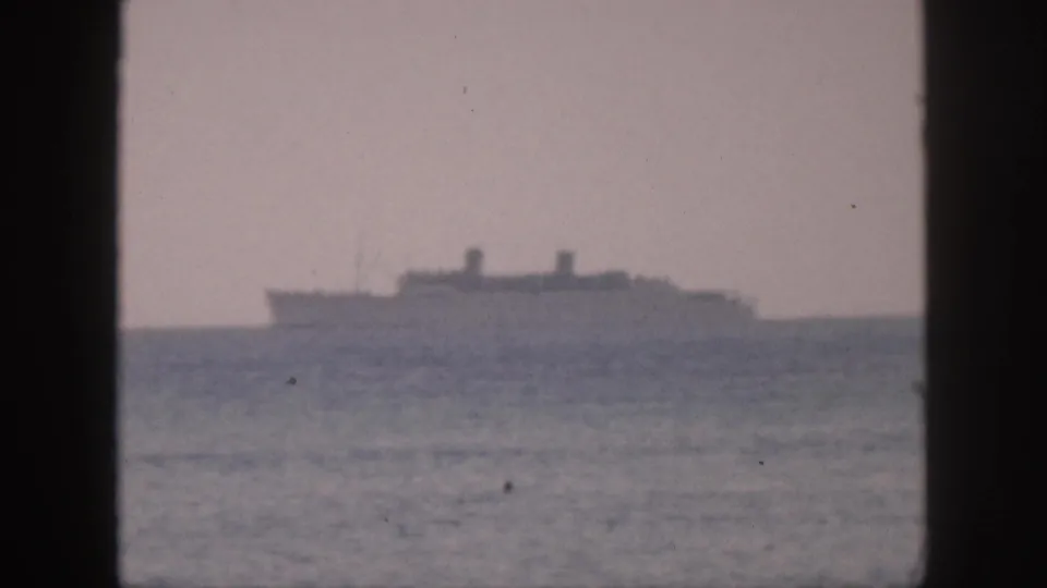 A distant passenger ship sits near the horizon in a 1959 Hawaii 8mm frame, with dark window-like borders and muted color.