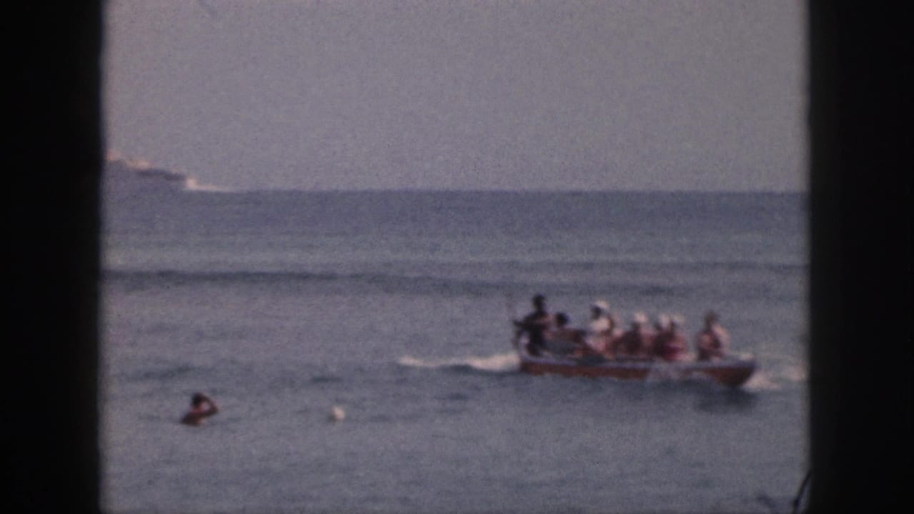 Open motorboat with passengers moves across the bay, framed by dark vertical edges and a distant horizon.
