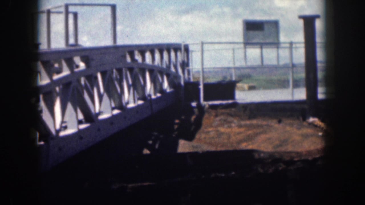 1959 Hawaii 8mm frame showing a weathered metal walkway, railing, and corroded platform near water.