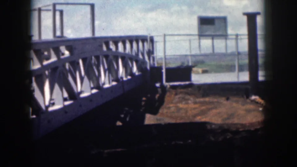 1959 Hawaii 8mm frame showing a weathered metal walkway, railing, and corroded platform near water.