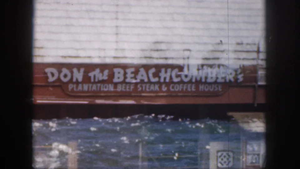 1959 Hawaii waterfront frame showing a Don the Beachcomber sign above water, with the restaurant wording partly legible below.