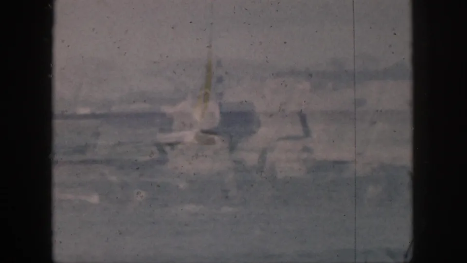 A lone surfer stands or balances near breaking surf in a soft, faded Hawaii 8mm frame from 1959.